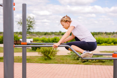 Side view of young woman holding railing