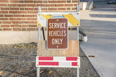 Information sign on road against wall