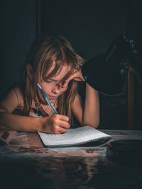 The child does homework, a letter in a notebook 