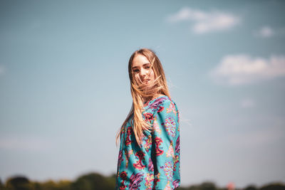 Portrait of woman standing against sky