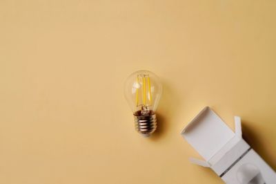 High angle view of light bulb on table against wall