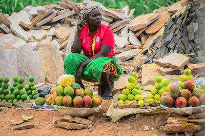 Rear view of woman standing by fruits for sale at market stall