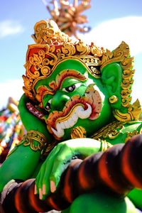 Low angle view of buddha statue against sky