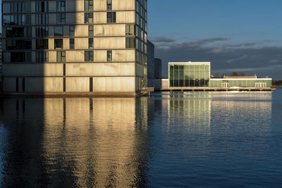 Reflection of building in river against blue sky