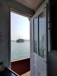 Ship sailing in sea seen through window