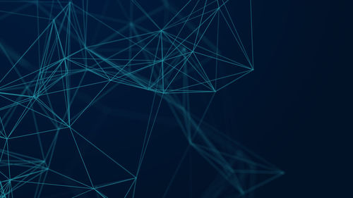 Low angle view of illuminated lighting equipment against black background