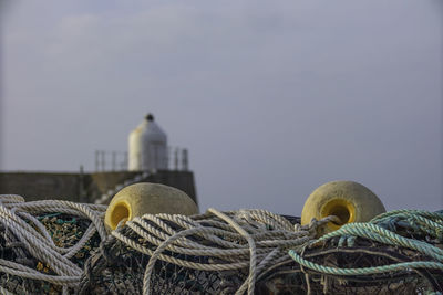 Close-up of fishing net at harbor against sky