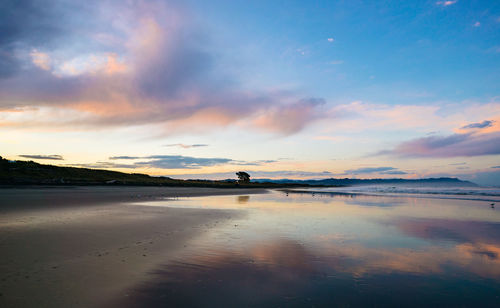 Scenic view of beach against sky during sunset