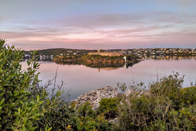 Scenic view of lake against sky at sunset