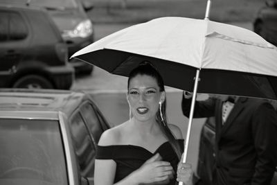 Portrait of woman with umbrella in city