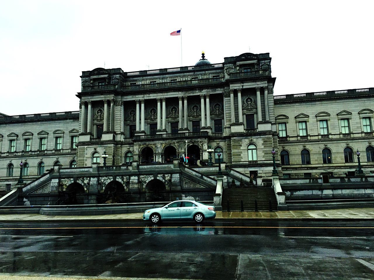 architecture, built structure, building exterior, transportation, city, famous place, travel, low angle view, travel destinations, mode of transport, history, car, clear sky, flag, capital cities, international landmark, flying, tourism, bird, incidental people