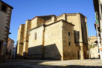 Low angle view of buildings against clear blue sky