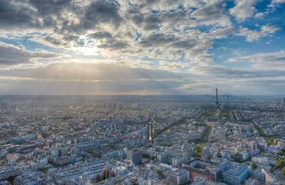 Aerial view of cityscape against cloudy sky