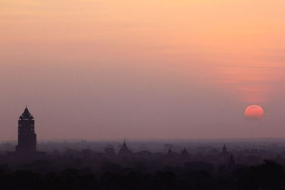 Silhouette buildings against sky during sunset