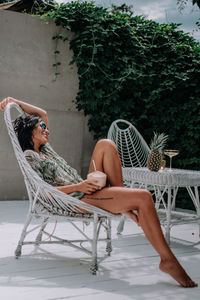 Woman sitting on chair in yard