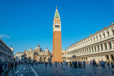 Group of people in front of building against blue sky