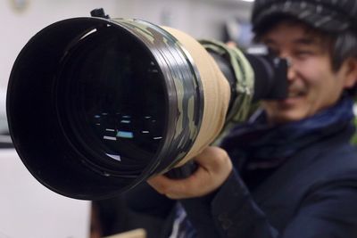 Close-up of man photographing with digital camera