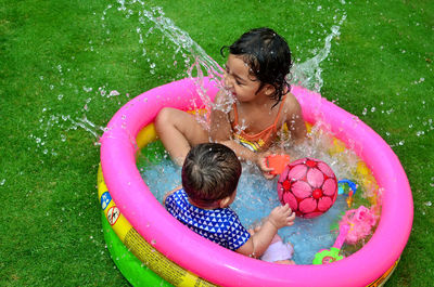 Water splashing on siblings in yard