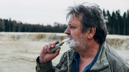 Man smoking electric cigarette outdoors