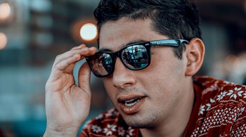 Close-up portrait of young man holding camera