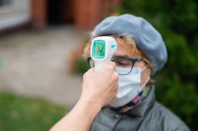 Close-up portrait of boy holding camera