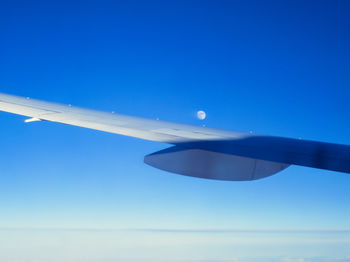 Low angle view of vapor trails against clear blue sky