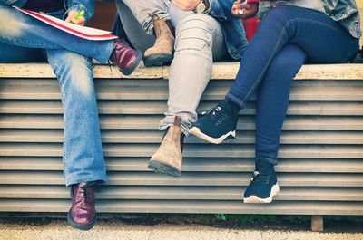 Low section of couple sitting on bench