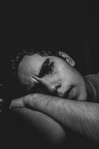 Close-up portrait of young man against black background