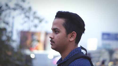 Profile view of thoughtful man standing against sky