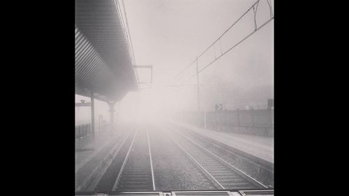 Railroad tracks in city against sky