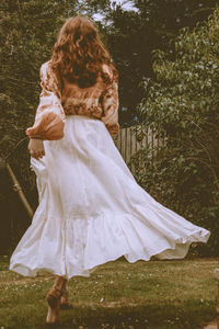 Rear view of woman with umbrella on field