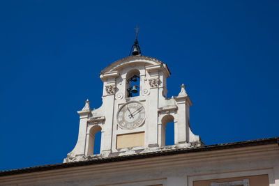 Low angle view of clock tower against clear blue sky