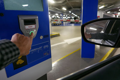 Cropped hand pressing parking meter button