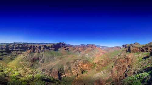 Scenic view of rocky mountains against clear blue sky