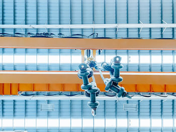 Overhead crane and machine inside factory building, industrial background.