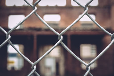 View of building seen through chainlink fence