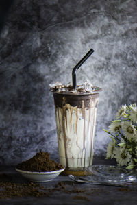 Iced chocolate with ice in the glass there is a drop of water on the side of the glass.