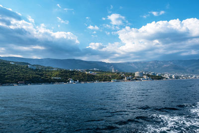 Scenic view of sea by buildings against sky