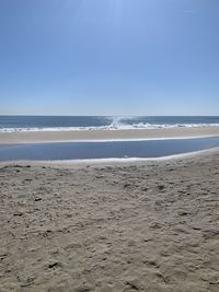 Scenic view of beach against clear blue sky