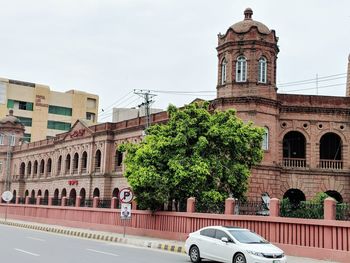 Building by street against sky in city