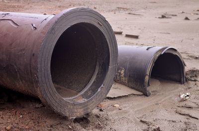 Close-up of abandoned pipe on sand