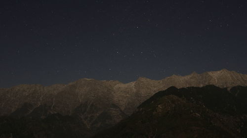 Scenic view of mountains against sky at night