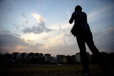 Silhouette man against sky in city