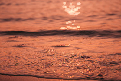 Surface level of beach against sky during sunset