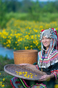 Smiling woman with yellow flowering plants