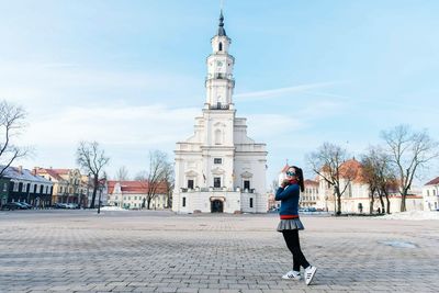 Portrait of woman posing against church in city