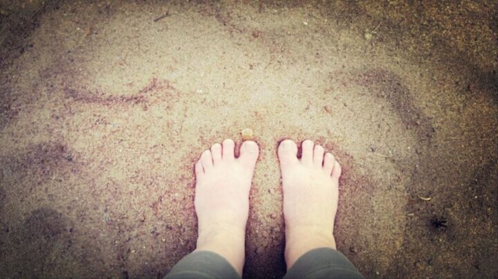 low section, person, personal perspective, human foot, shoe, standing, lifestyles, high angle view, sand, beach, barefoot, leisure activity, part of, footwear, directly above, unrecognizable person