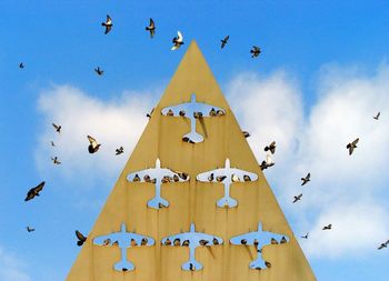 Low angle view of bird flying against blue sky