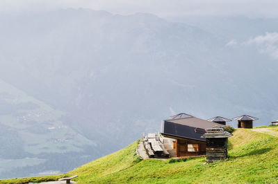 Built structure on field by mountain against sky