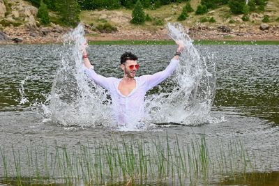 Young man splashing water in lake